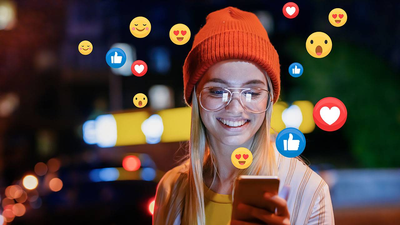 Woman engaging with viral social media content on her phone with engagement emojis surrounding her