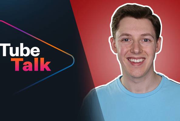 Smiling young man in blue shirt with Tube Talk logo on dark and red background.